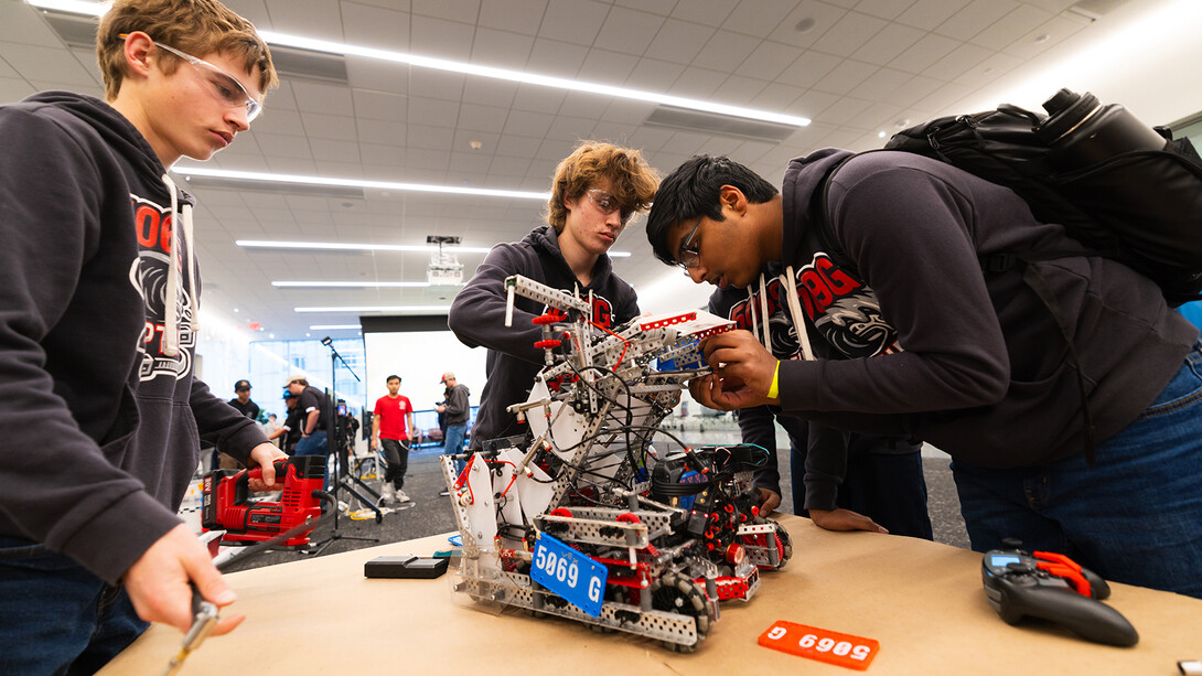 Members of Ziptide, a VEX Robotics team at Millard North High School, finish attaching color-coded tags to their robot before a semifinal round. This is the third year the University of Nebraska–Lincoln's VEX Robotics team has hosted a high school tournament at Kiewit Hall.