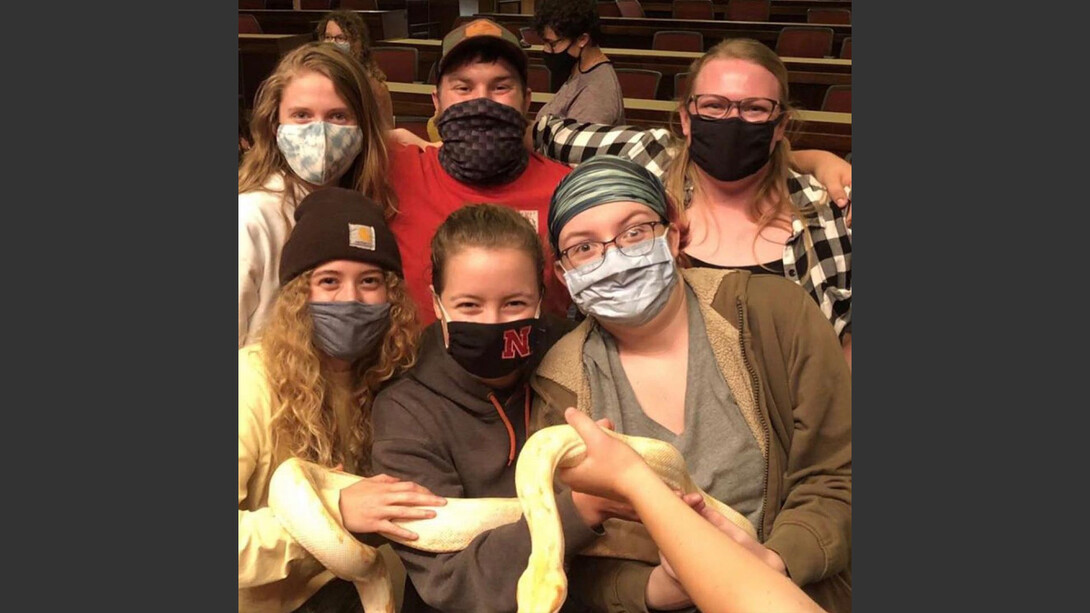 Students hold an albino snake