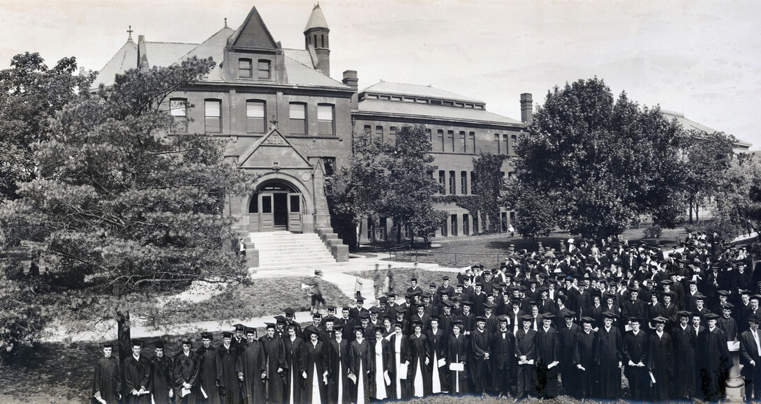 Architecture Hall, shown here in an undated photo featuring graduates, is among the three original buildings still standing in NU's first four block plot. The other two buildings (not shown) are Brace Labs and Richards Hall.