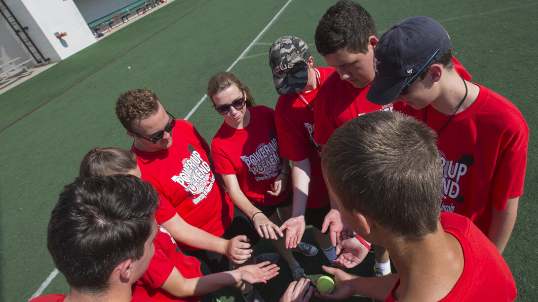 A Power Up Weekend team works to pass a tennis ball around in a circle in under two seconds. Jackson Moffett (third from right) traveled more than 1,450 miles with his family to attend UNL's Power Up Weekend activities.