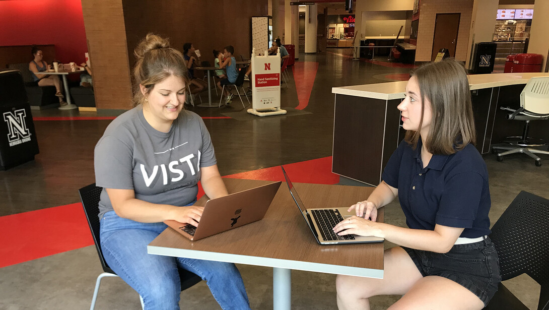 Candace Hulbert, the Weather Ready Farms VISTA, talks with Julien Hoffman, AmeriCorps VISTA program coordinator with Nebraska Extension, in the Nebraska Student Union