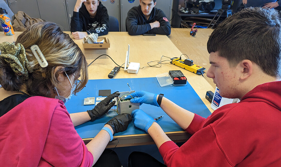 Students work on the satellite cube.