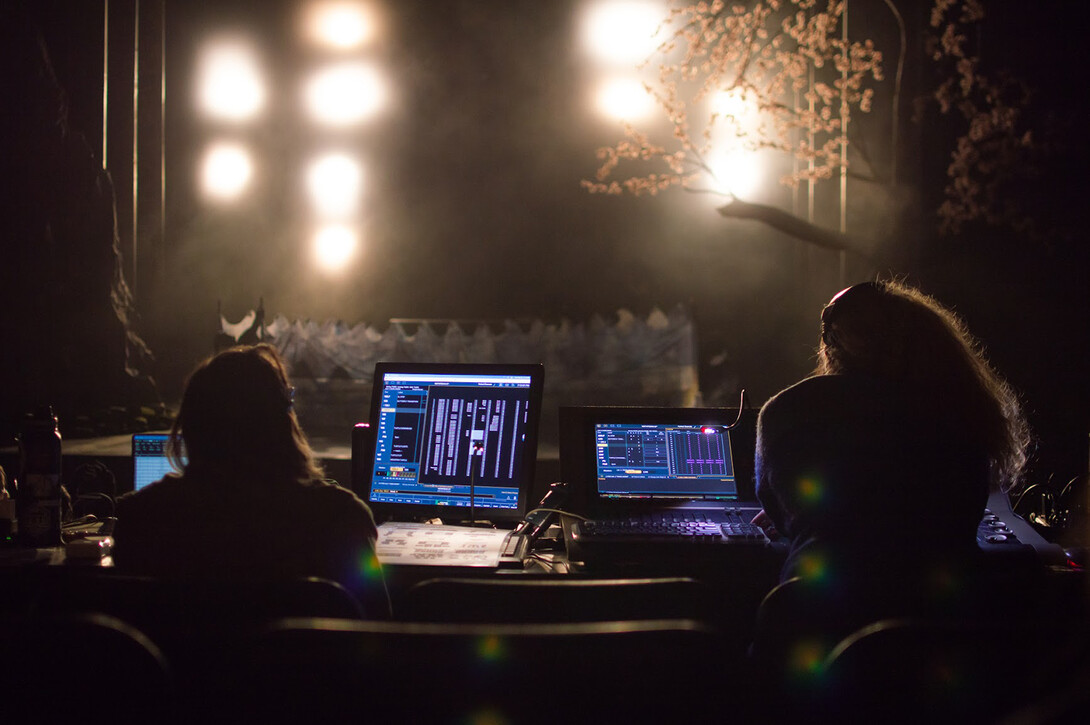 Members of the Nebraska Rep tech crew operate lighting and special effects during a dress rehearsal. The production is in the Temple Building and features student and professional performers.