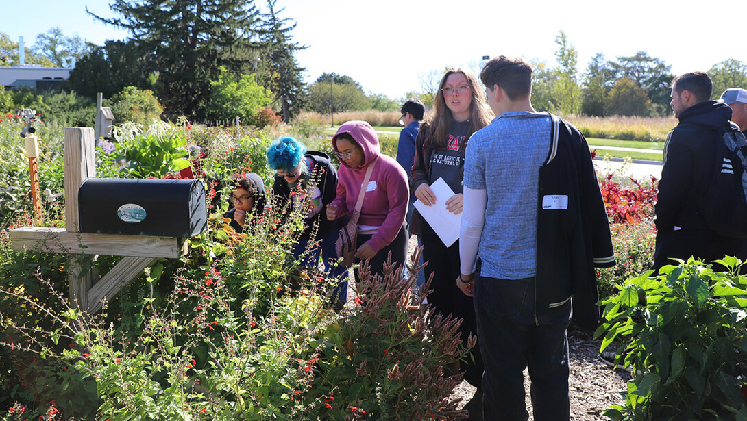 Christine Barta (center, in gray sweatshirt) leads a tour through gardens on East Campus. 