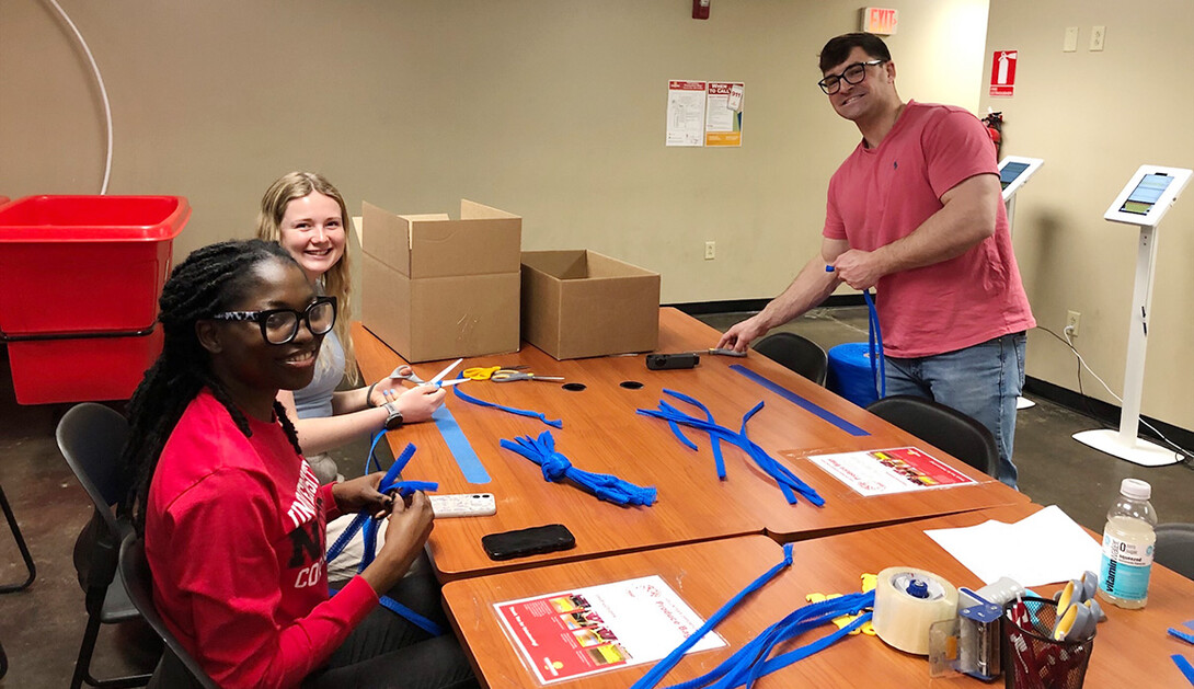 Promise Emmanuel (left), MaKenna Clinch and Ben Bentzinger assemble hygiene kits.