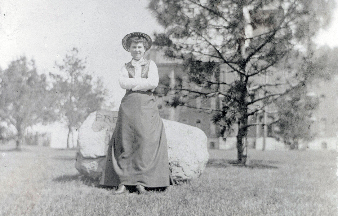 Willa Cather poses in front of a rock while she was on the University of Nebraska campus. The rock is now located in front of Morrill Hall.