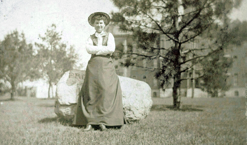 Willa Cather poses in front of a rock while she was on the University of Nebraska campus. The rock is now located in front of Morrill Hall.