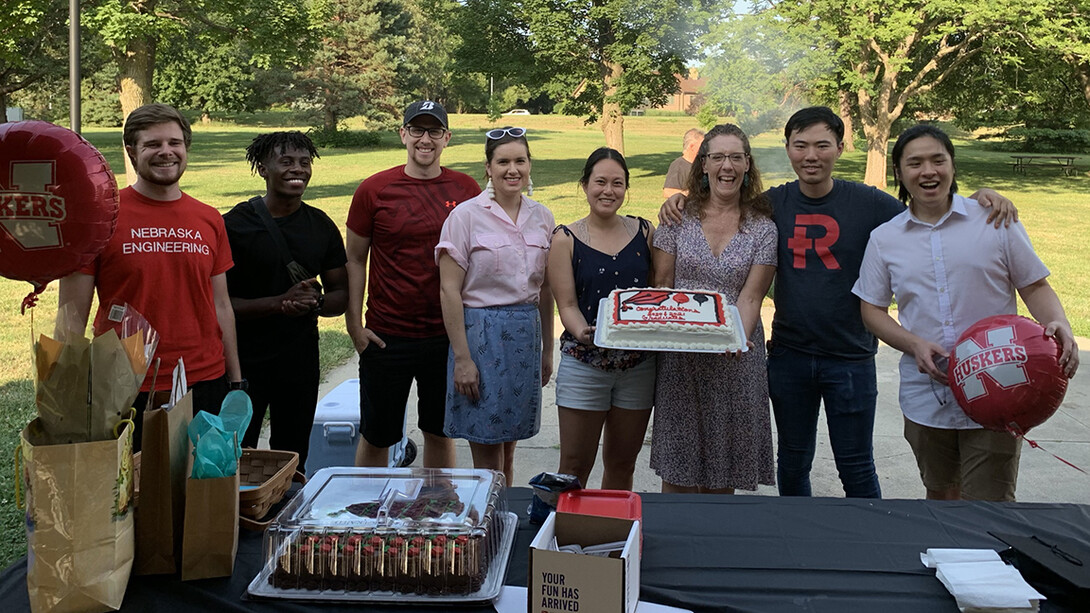 Mikki Sandin holds a cake during a celebration of Nebraska graduates.