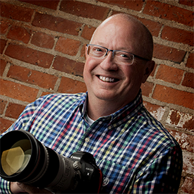 Photo of Craig Chandler holding a camera.