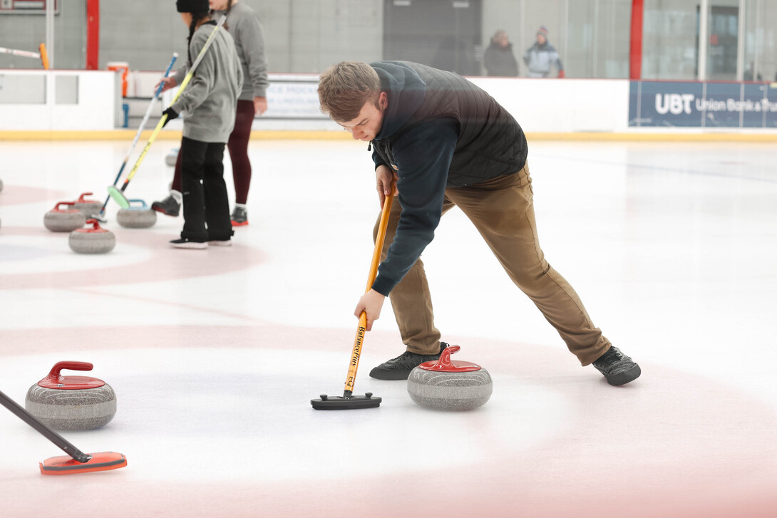 Ethan Vermeeren sweeps the stone as it heads to the center of the circle known as the button.