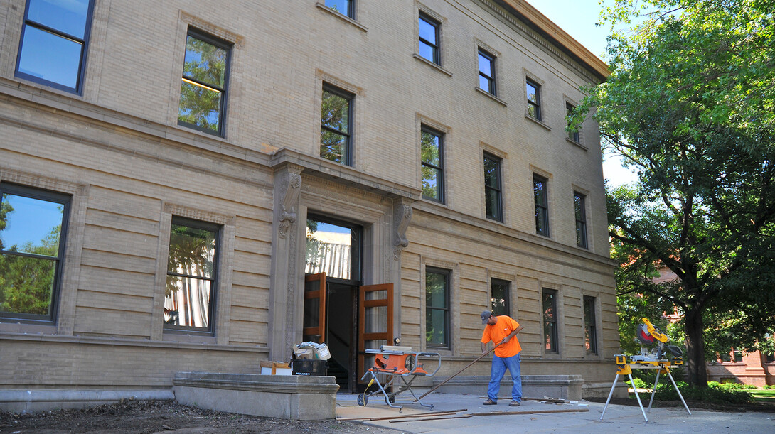 Quain VanArsdel cuts wood trim outside of UNL's  Brace Laboratory on Aug. 18.