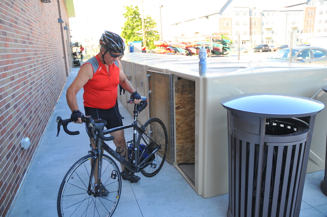 Craig Munier removes his bike from the storage lockers outside UNL's new Outdoor Adventures Center. The center includes UNL's first dedicated bike commuter facility.