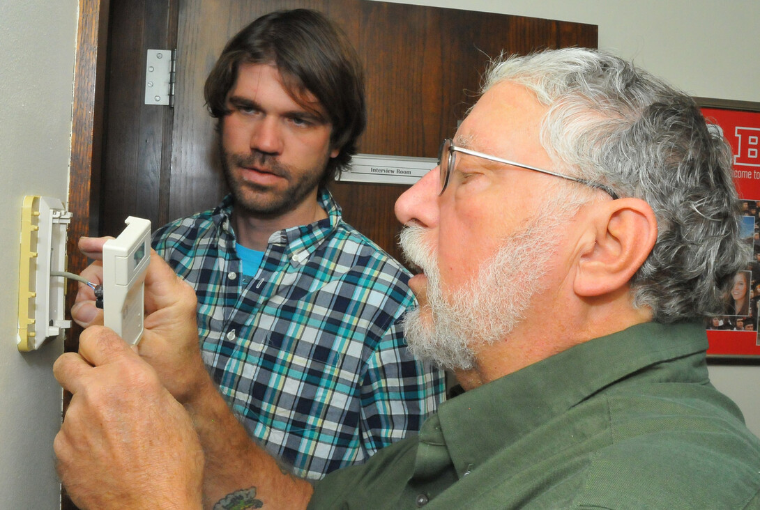 Steve Waltman (right) and Josh Taylor reset a thermostat in the Nebraska Union. Waltman, a building mechanic, retires Oct. 31 after working more than 30 years at UNL. Taylor is taking over for Waltman.