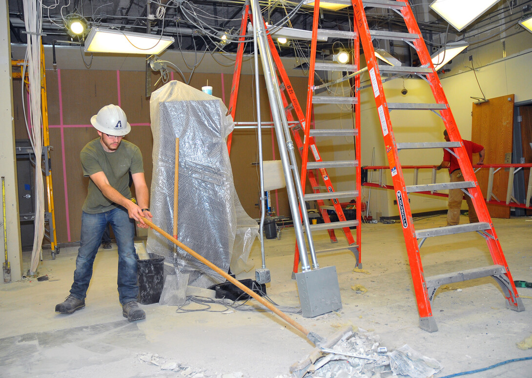 Josh Moser of Ayars and Ayars sweeps inside the space that will be Nebraska Union's redesigned welcome desk and Caffina Café. The space is scheduled for completion in early January. (© 2013, The Board of Regents of the University of Nebraska. All rights reserved.)