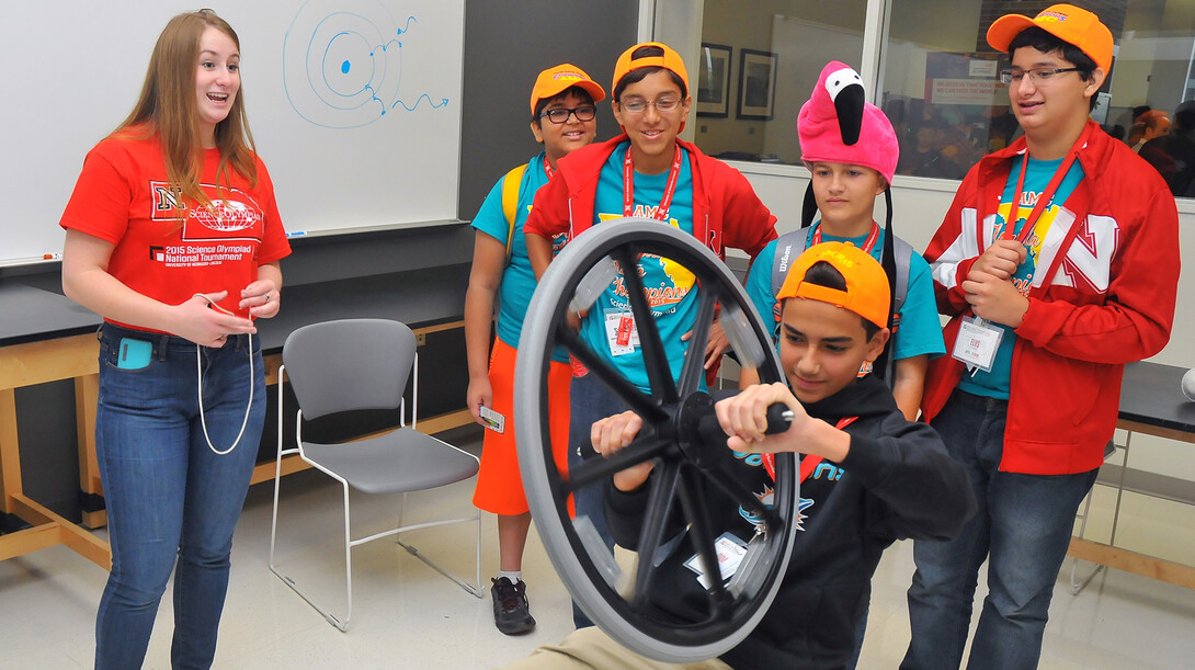 Savanna McDonald (left), a senior physics major from Omaha, shows Science Olympiad competitors from Florida how a gyroscope works during the STEM Expo in Jorgensen Hall on May 15.