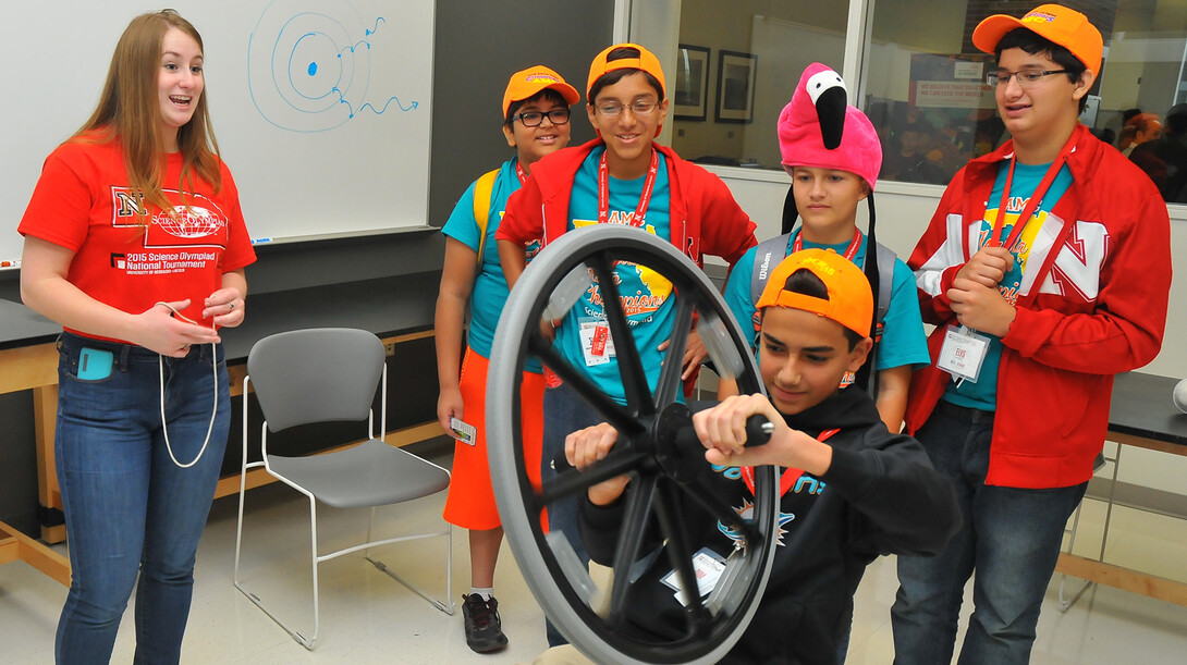 Savanna McDonald (far left), a senior physics major, demonstrates the principles of a gyroscope during a science, technology, engineering and mathematics exposition in Jorgensen Hall during the Science Olympiad National Tournament in May. UNL has received a three-year NSF grant to help meet the growing need for middle and high school science teachers.