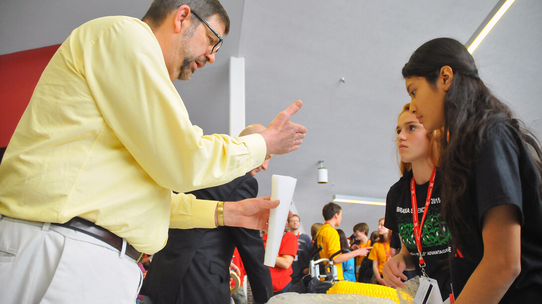 UNL's Tim Gay, professor of physics, works with Omaha-area science students during the build portion of the May 15 egg drop competition. Organized by UNL, the egg drop was part of the 2015 Science Olympiad National Tournament.