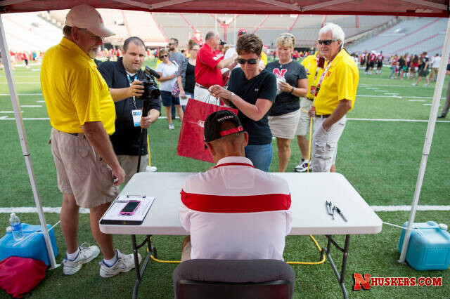 Nebraska head coach Mike Riley signs an autograph during UNL's 2015 Fan Day at Memorial Stadium.