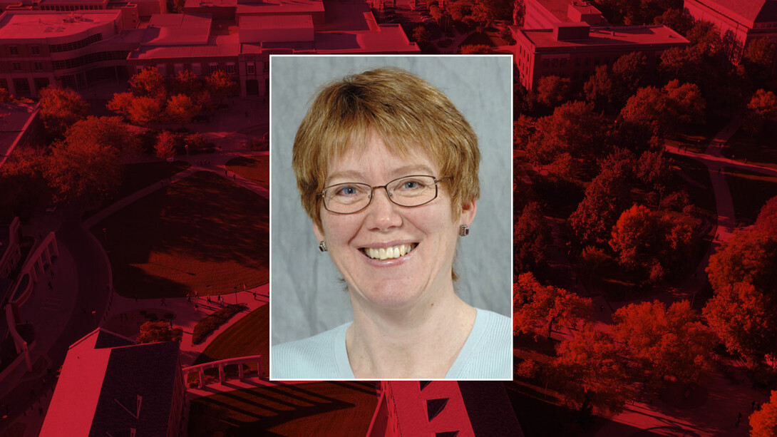 A headshot of a female professor is surrounded by a red background.