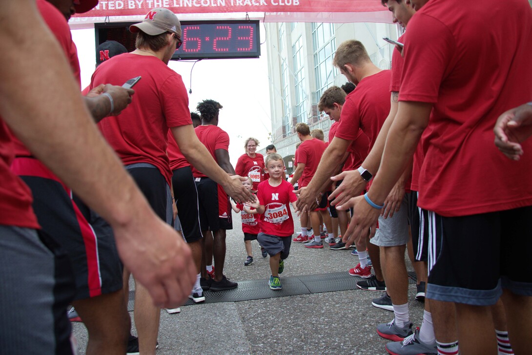 Nebraska athletes greet participants in the Nebraska Football Road Race. The seventh-annual event is July 14.