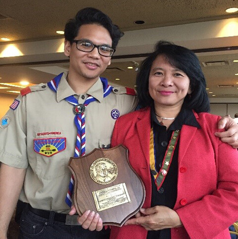 Roz Hussin (left) stands with her son after receiving the Whitney M. Young Jr. service award from the Boy Scouts of America.