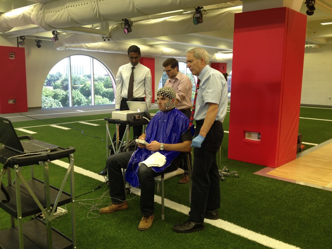 Dennis Molfese (right) demonstrates the EEG technology and memory match test used to research post-concussion effects in athletes in the Nebraska Athletic Performance Lab in 2013.