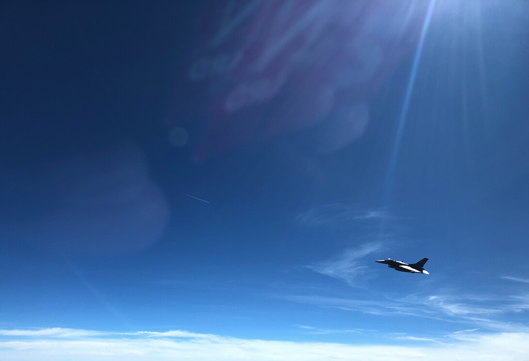 An F-16 flies alongside the Stratotanker during refueling operations. The fighter is part of the South Dakota National Guard.