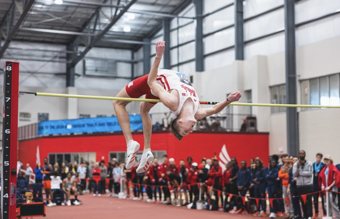 Tyus Wilson clears the high jump bar at an indoor track and field meet.