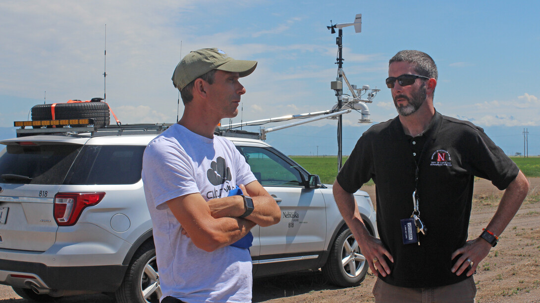 Nebraska's Adam Houston (right) talks with a colleague during a storm chase.