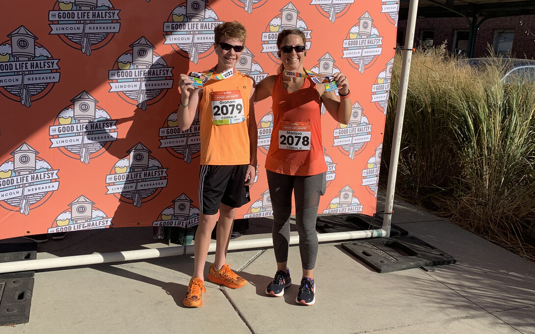 Marissa James and her son pose with Good Life Halfsy medals after competing the race in 2022.