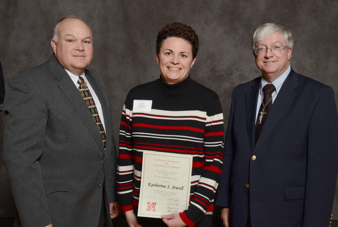 Katie Jewell (center), associate director of academic programs for athletics, accepts her Parents Association award from (left) Bryan Reiling, chair of the UNL Teaching Council and Timothy Draftz, co-president of the UNL Parents Association.