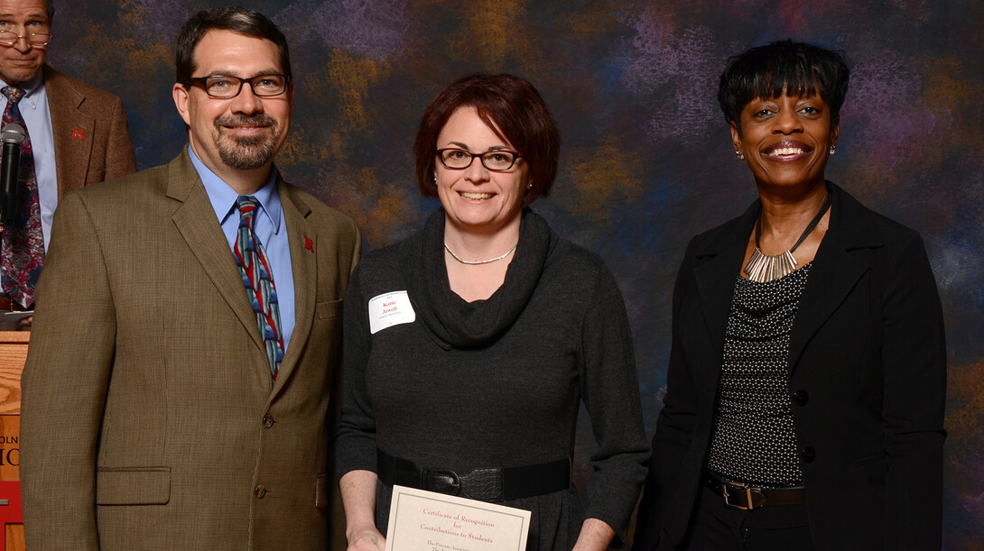 Katie Jewell (center), associate director of academic programs for athletics, accepts her thirteenth UNL Parents Recognition Award from (left) Scott Napolitano, chair of the UNL Teaching Council, and Tanis Herbert, co-president of the UNL Parents Association. More than 190 UNL faculty and staff received the annual awards during a Jan. 29 ceremony.