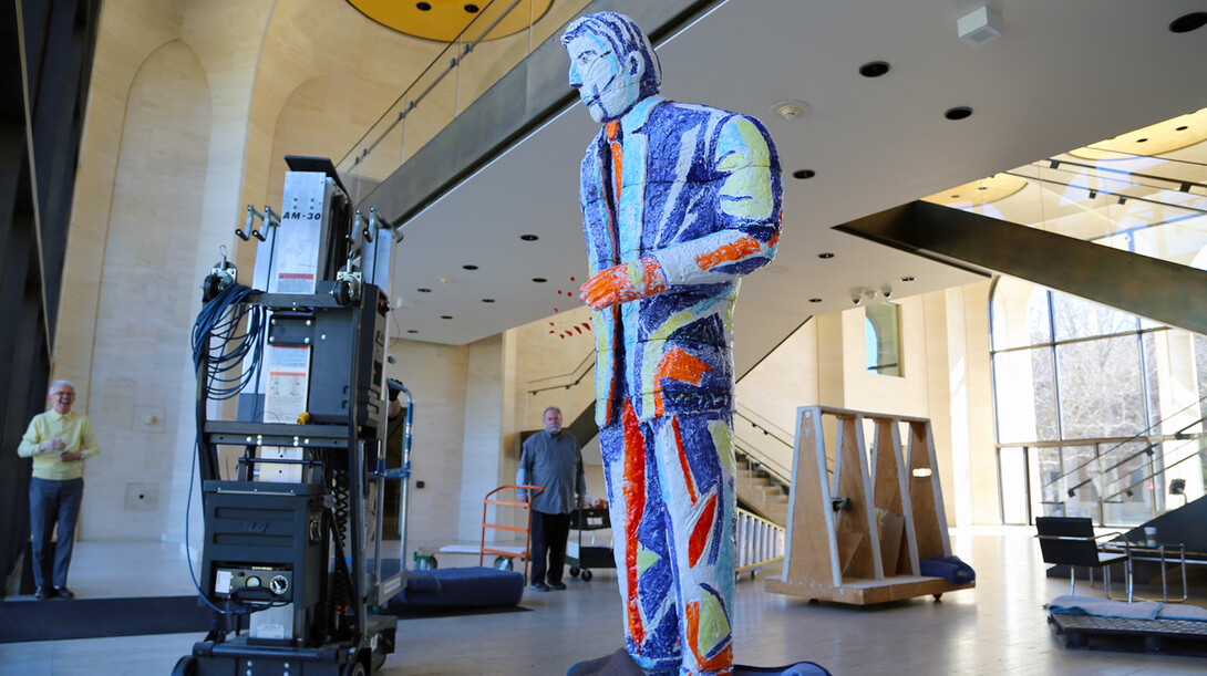 Wally Mason (left), director of the Sheldon Museum of Art, smiles as Ed Rumbaugh, retired museum preparator, stops to look at "Handout Man" after the sculpture was assembled on March 30.