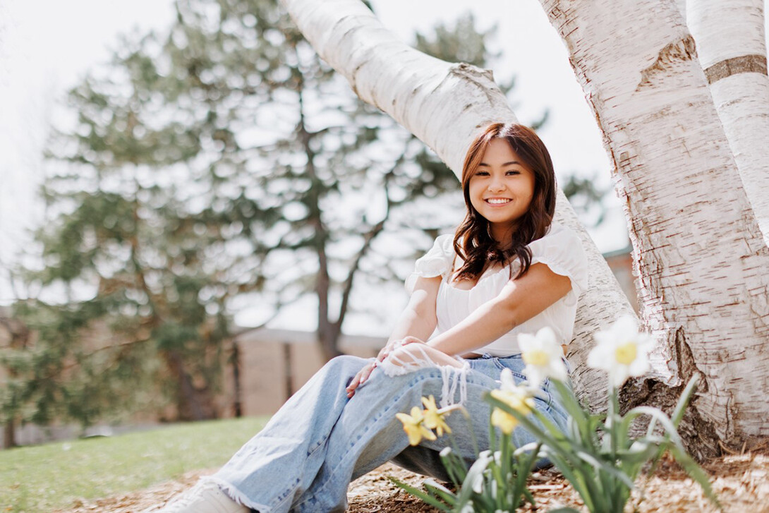 Nebraska's Kaitlyn Nguyenduy leans against a birch tree in the sculpture garden west of Sheldon Museum of Art.