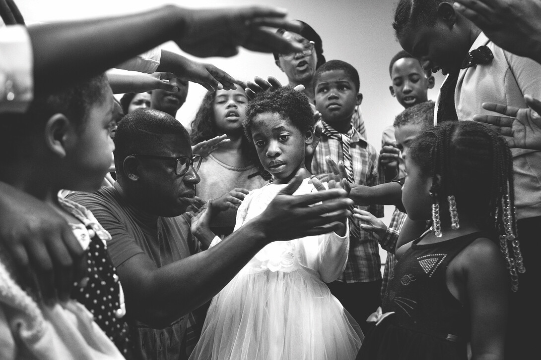 Members of the New Life Tabernacle congregation pray over Josnika Adult, 5, on Oct. 22, 2017, in Belle Glade, Florida.