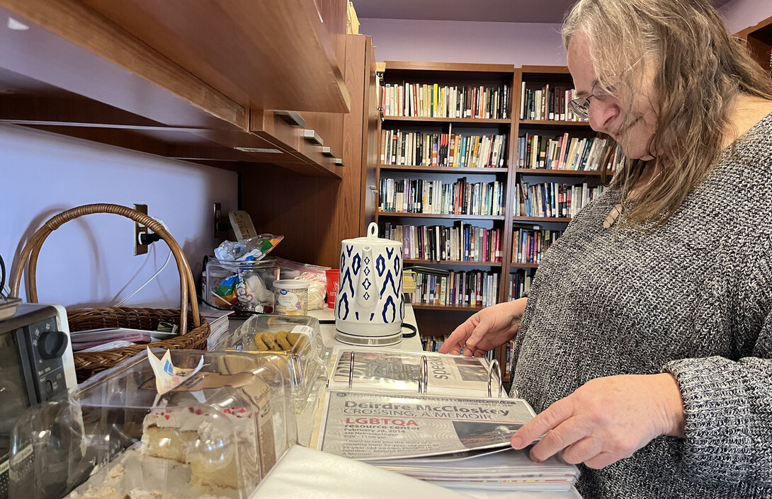 Pat Tetreault, director of the LGBTQA+ Center, looks through scrapbooks of various events held by the center since its founding in 2007.