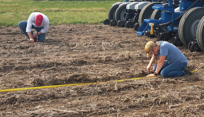 Joe Luck (left) and Rachel Stevens check seed placement of a multi-hybrid planter being tested as part of a collaborative research project being conducted by university researchers, industry and growers.