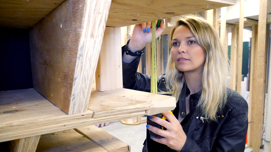 Maren Elnes, a graduate student in architecture, double checks measurements at the new interior facility at Omaha's Bemis Center.