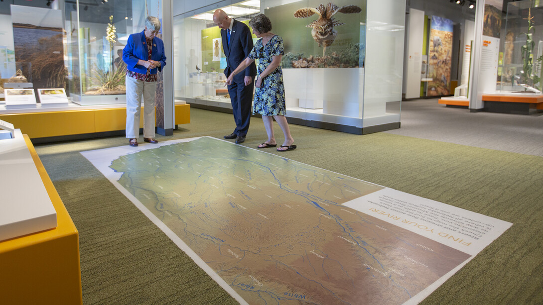 Susan Weller (left) and Michelle Waite (right) discuss Nebraska's multiple rivers with Governor Pete Ricketts in the NU State Museum's "Cherish Nebraska" exhibition.