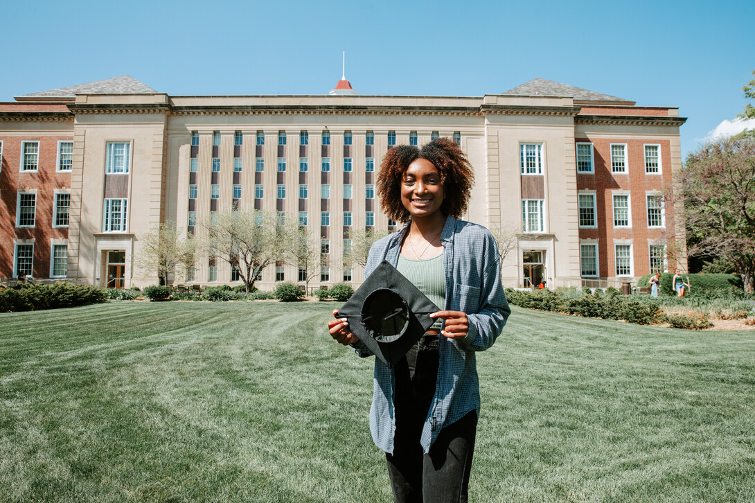 Standing in front of Love Library, Wright shows off a Grad Cap Remix insert.  