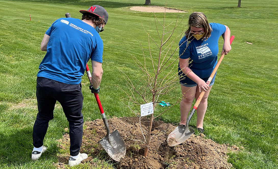 Nebraska Strong Recovery Project outreach workers plant a tree in Nebraska City during an Arbor Day festival. 