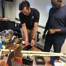 Daniel Uden (right) demonstrates GPS equipment with Samuel Nshutiyayesu (right).