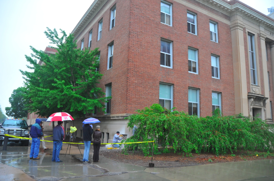 Individuals watch the removal of the Avery Hall cornerstone on May 12.