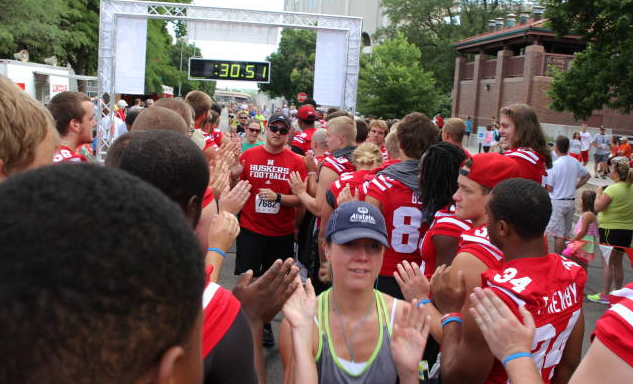 Husker football athletes greet runners at the end of the 2013 Uplifting Athletes Road Race. Registration is open for the 2014 race, which is July 20.