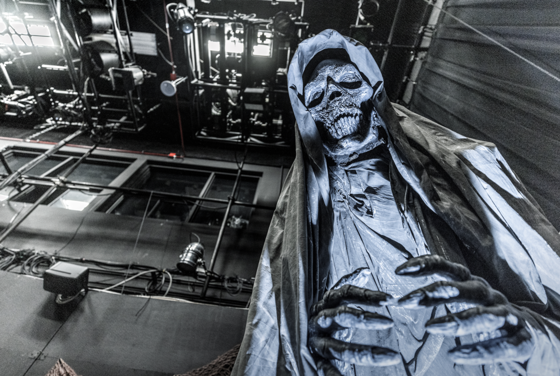 Large blue skeleton figure looming in haunted house