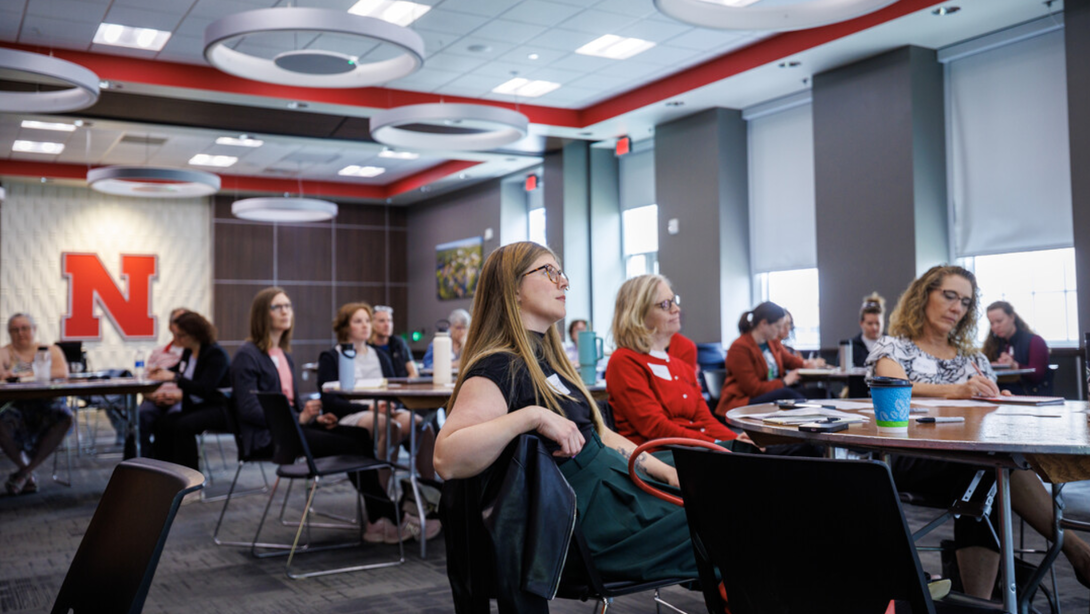People sitting at tables during a staff training session.
