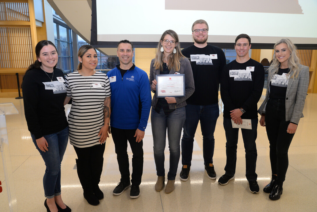 Lizzie Mattox, executive director of City Impact, receives recognition for the $5,000 grant her organization was awarded at the ceremony.