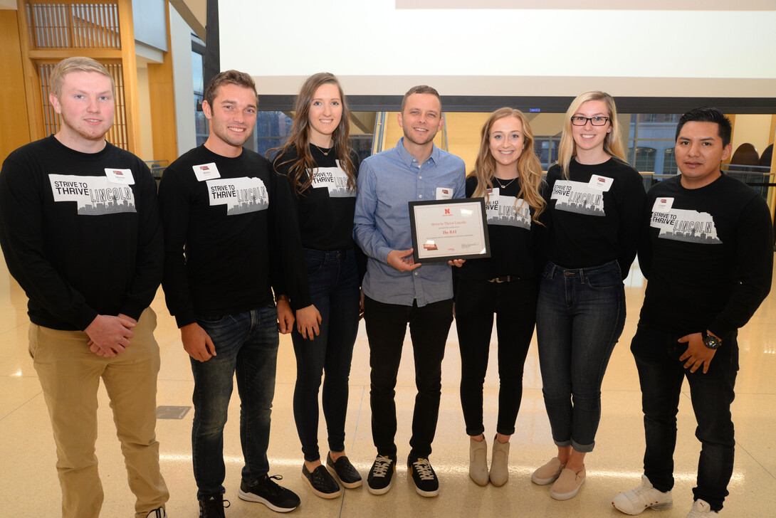 Mary Morton (second from right), Strive to Thrive Lincoln student, and classmates present Andrew Norman (center), executive director of The Bay, with grant award at final ceremony.