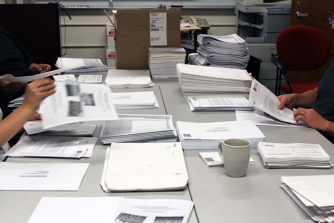 Bureau of Sociological Research employees prepare a survey for a mailing. The bureau averages a survey return rate of around 30 percent.