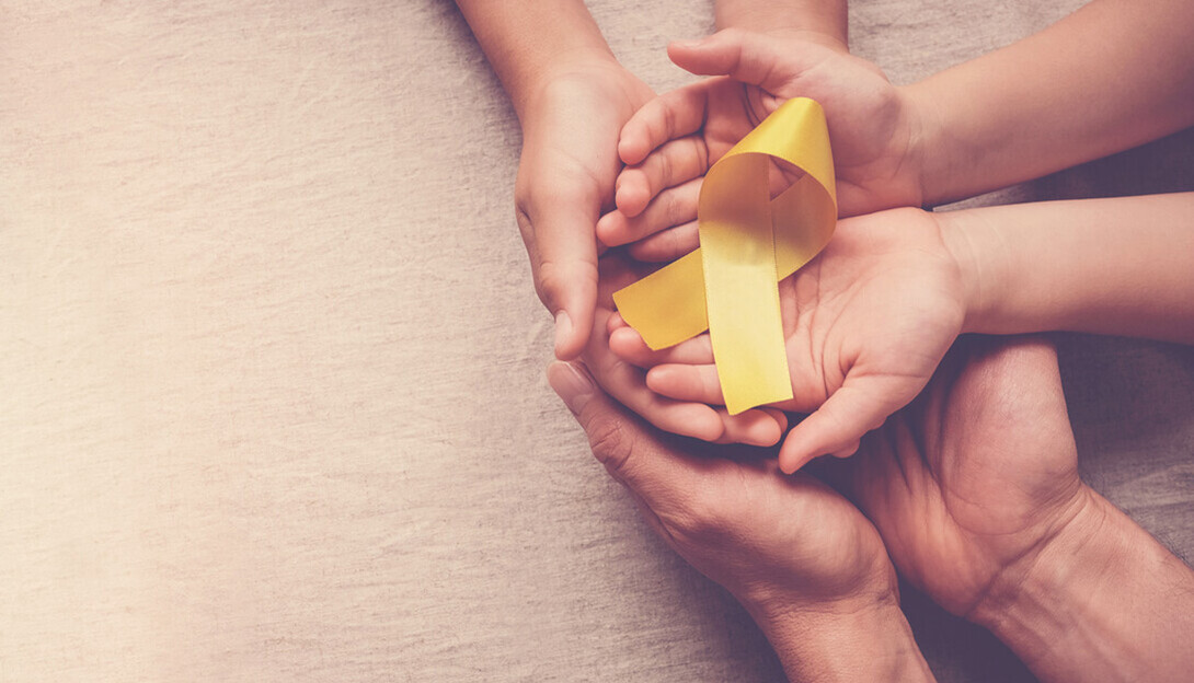 hands hold a yellow ribbon.